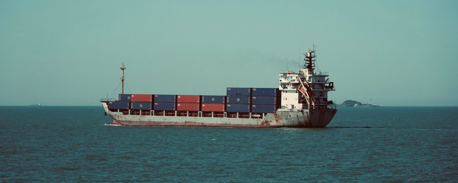 A container ship under way at sea with a full deck of containers