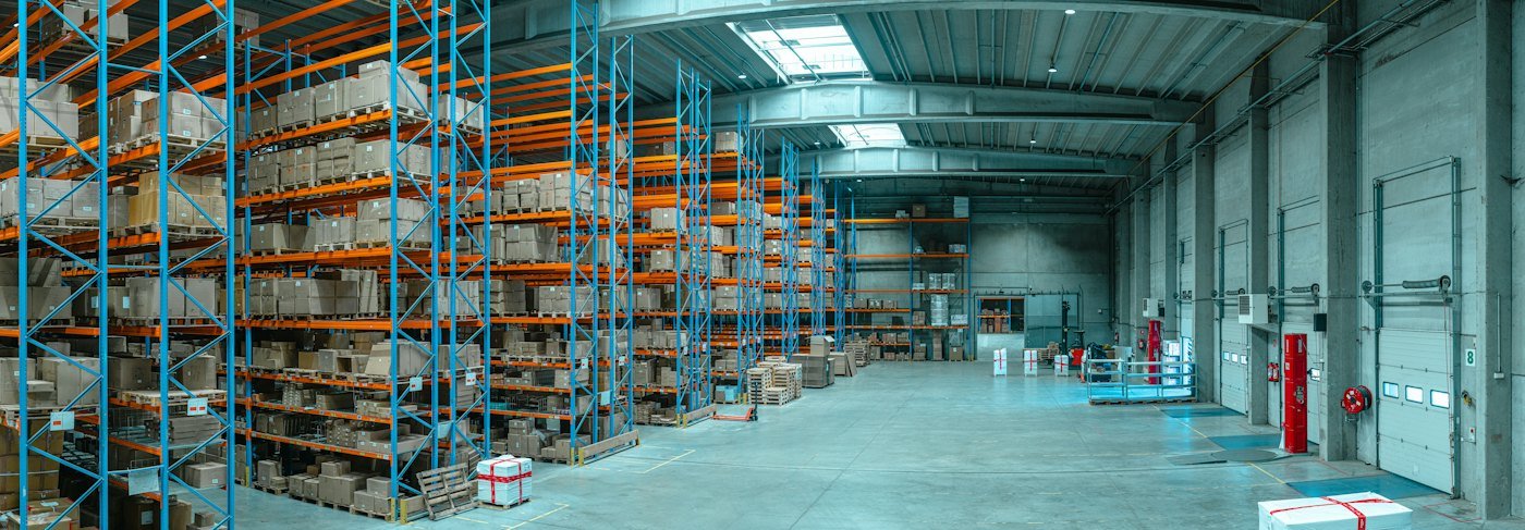 Warehouse interior with tall pallet racking stocked on every level